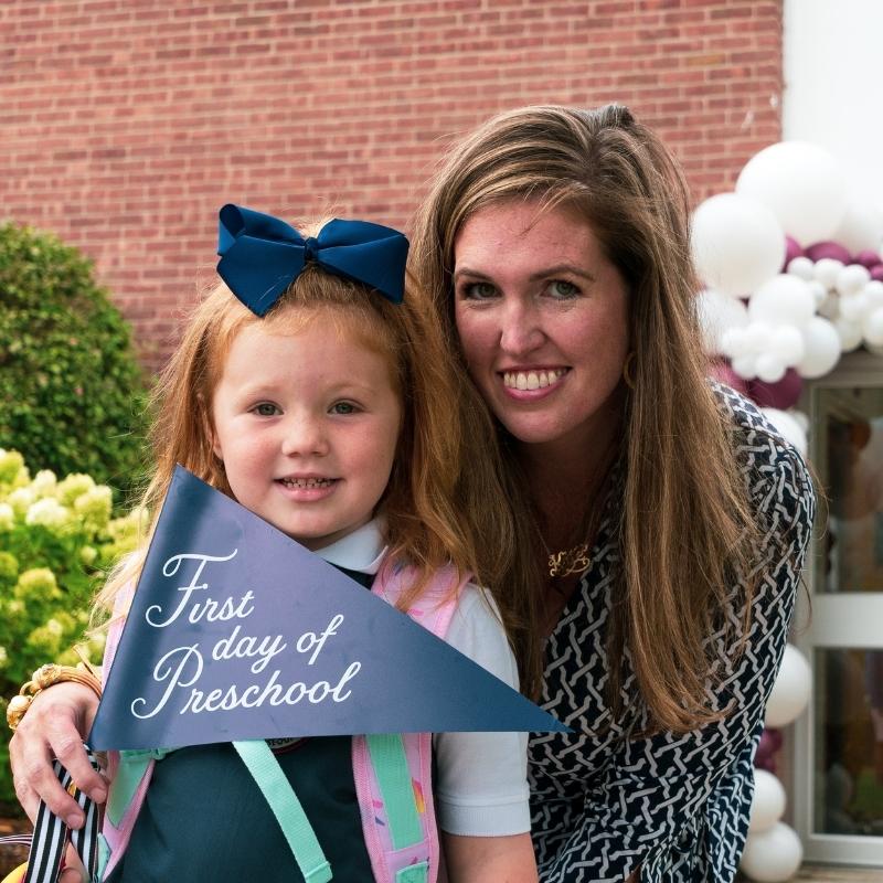 Private school pre-schooler and her mom in front of the Saint Gregory's School building on the first day of school