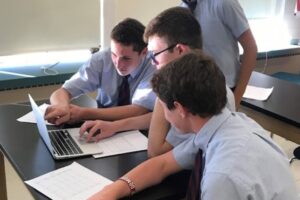 Three private school students studying together at a desk in Albany, NY