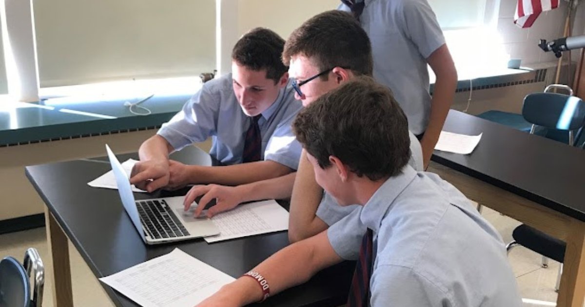 Three private school students studying together at a desk in Albany, NY