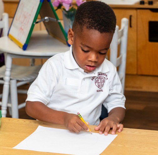 private school student concentrating on his task in a classroom in Albany, NY